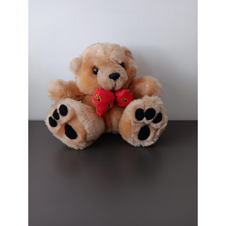 Kleine knuffelbeer met rode strik