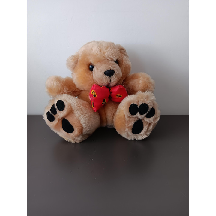 Kleine knuffelbeer met rode strik