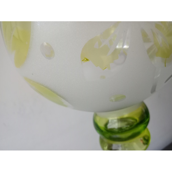 Glazen kaarsenhouder op voet met groengele bloemen