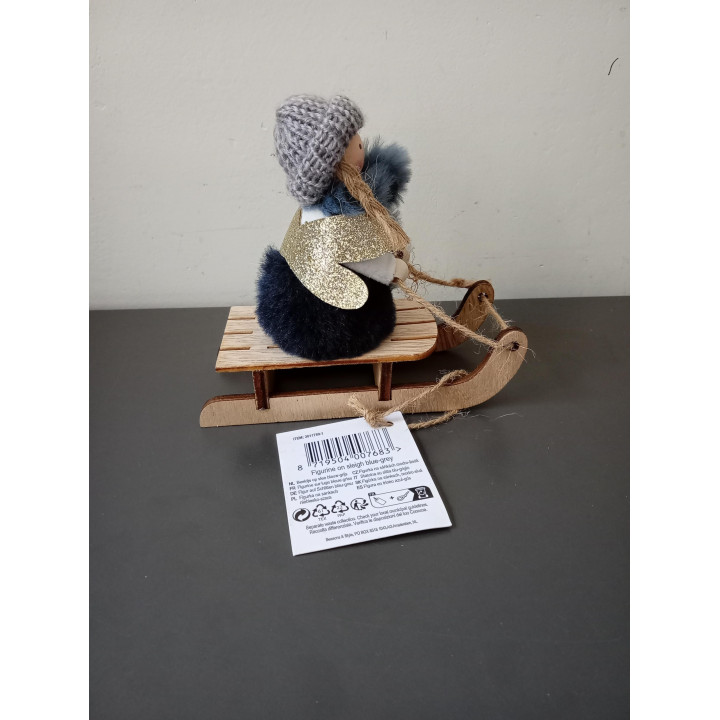 Decoratief meisje op houten slee met gebreide muts