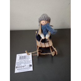 Decoratief meisje op houten slee met gebreide muts