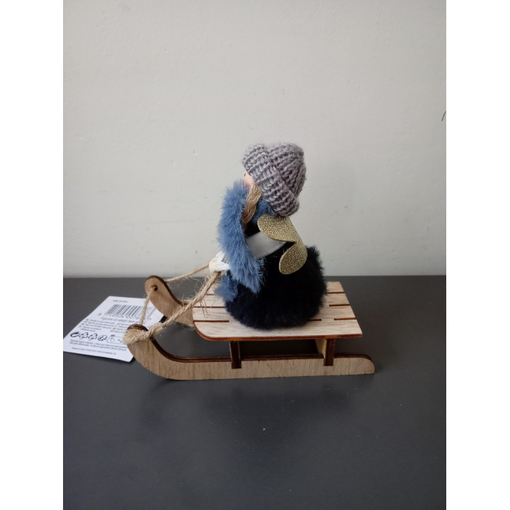 Decoratief meisje op houten slee met gebreide muts