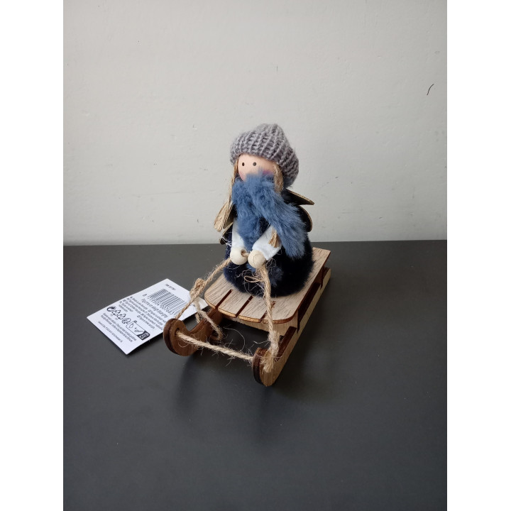 Decoratief meisje op houten slee met gebreide muts