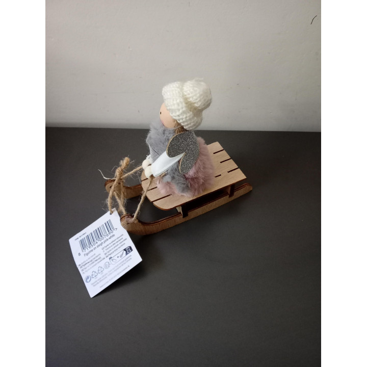 Decoratief meisje op houten slee met gebreide muts