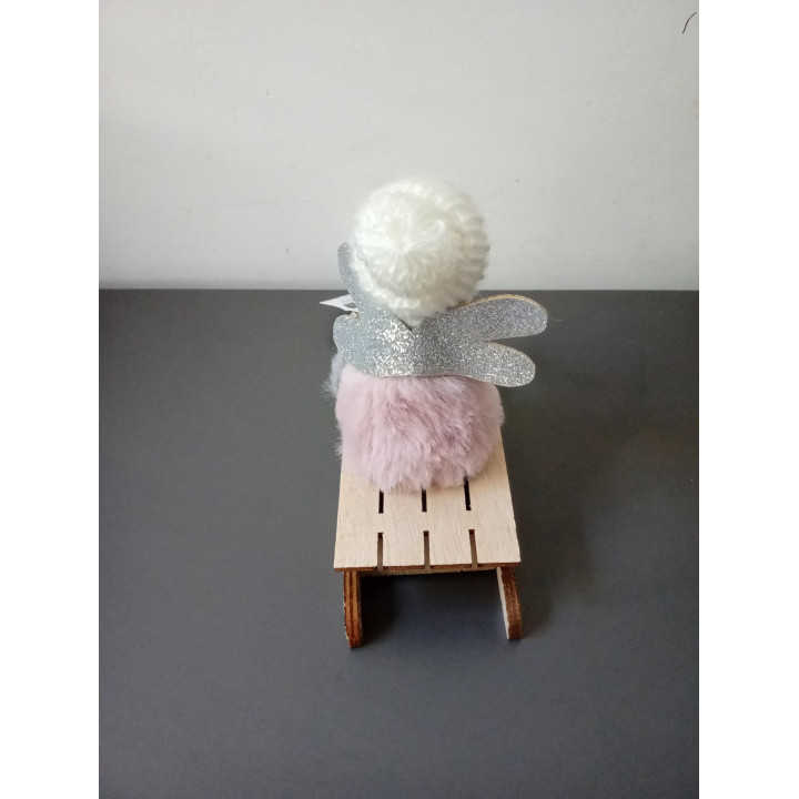 Decoratief meisje op houten slee met gebreide muts
